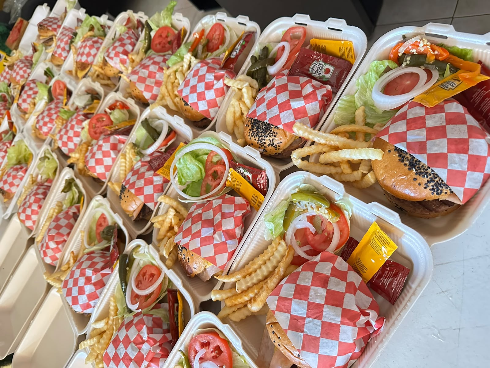 Hamburguesas empacadas para llevar, listas para entrega en un evento